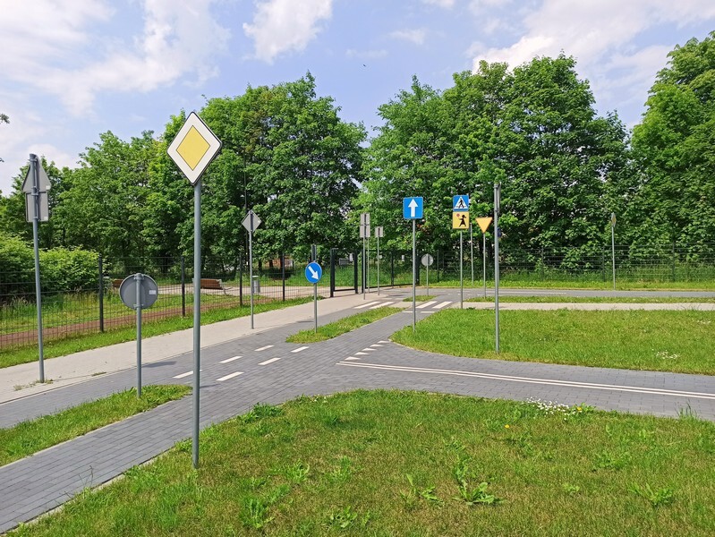 W Rudzie Śląskiej-Wirku od trzech lat istnieje Miasteczko Ruchu Drogowego. Letnia aura, która towarzyszy nam od kilku dni to dobry czas na odwiedzenie tego miejsca wraz z dziećmi. Poprzez zabawę można je nauczyć zasad poruszania się po chodniku i jezdni.
Przypomnijmy, że Miasteczko Ruchu Drogowego znajduje się przy ulicy Kolberga w Rudzie Śląskiej. Powstało jesienią 2018 roku, a projekt został zgłoszony w budżecie obywatelskim na rok 2017. Koszt inwestycji wyniósł 1,2 mln zł. Tuż obok znajduje się tor modelarski oraz plac zabaw z trampolinami, urządzeniem wielofunkcyjnym ze zjeżdżalnią, a także mini parkiem linowym oraz tyrolką. Jako, że obiekt usytuowany jest na uboczu, jest tu cicho. Cały teren został ogrodzony, dzięki czemu dzieci mogą spokojnie uczyć się zasad ruchu drogowego.